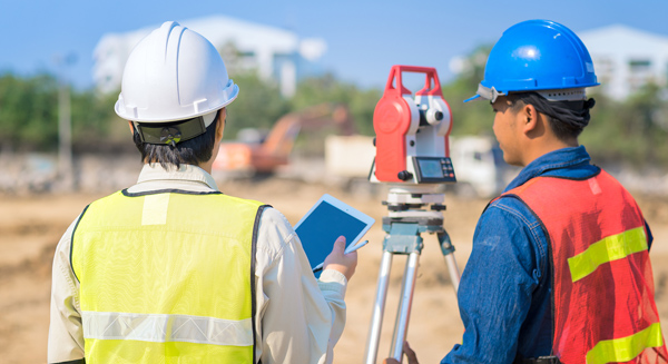 two men with land surveying equipment