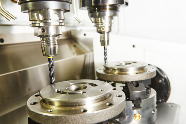 Milling machine tool with two mills in chuck preparing to process metal detail at industrial manufacture factory